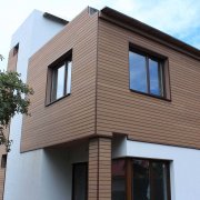 Face à la façade d'une maison en bois: technologie et design